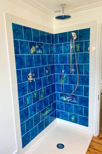 Selection of fish tiles with matching plain turquoise tile in a shower