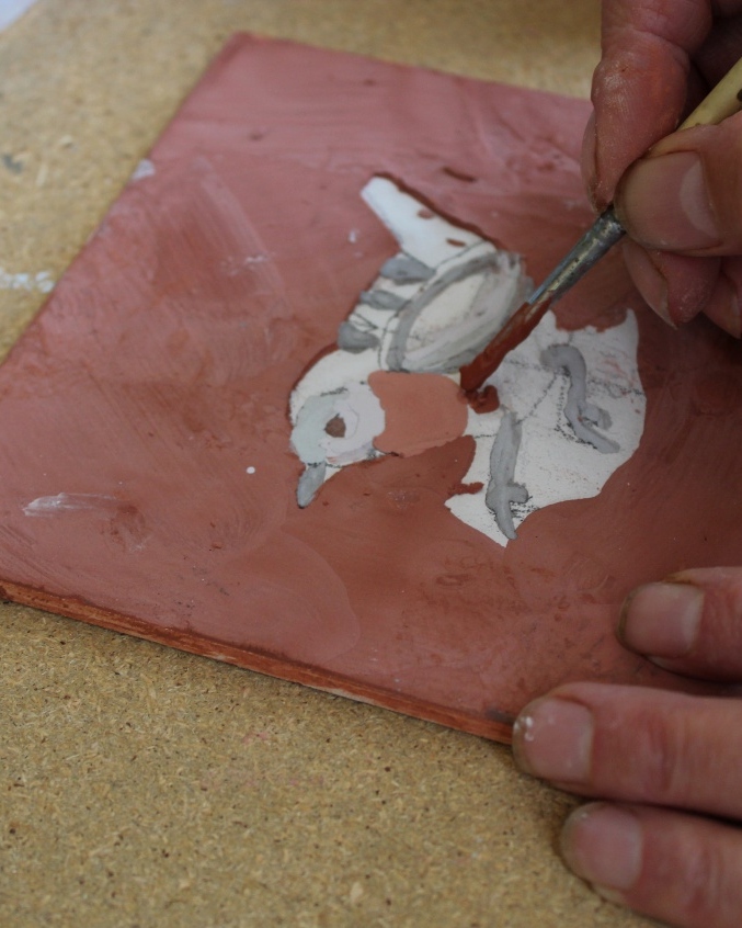 Hand painting a garden bird tile